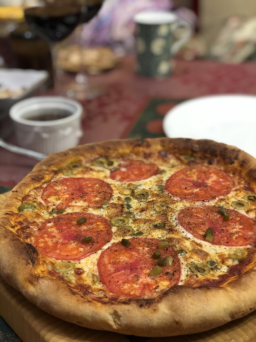 На фото пицца с начинкой: томатный соус, моцарелла для пиццы, томаты без кожицы, оливки, маринованная черемша.