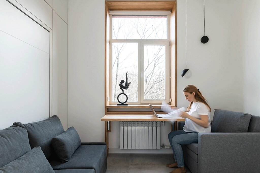 Экран перед радиатором перевоплощается в рабочее или обеденное место. Светильники подвесы позволят работать с ноутбуком и читать сидя в кресле в темное время суток. 