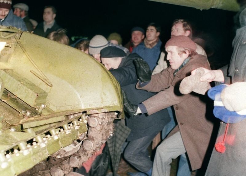 Люди пытаются остановить танк, который наехал на протестующего