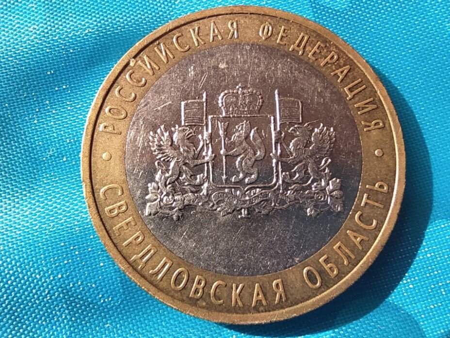 10 Рублей Свердловская область. Юбилейная монета Свердловская область. Как выглядит эта монета. Монета 10 р на столе. Памятная монета свердловская область