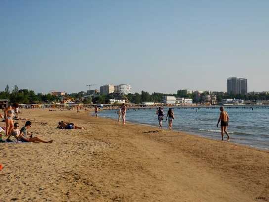 На пляже достаточно много народу, с учетом карантина.