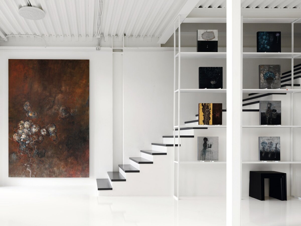 На стене и на стеллаже из мастерской @experimental_factory выставлены работы Алексея Теренина. Светильник, Artemide; столики, Mint Furniture