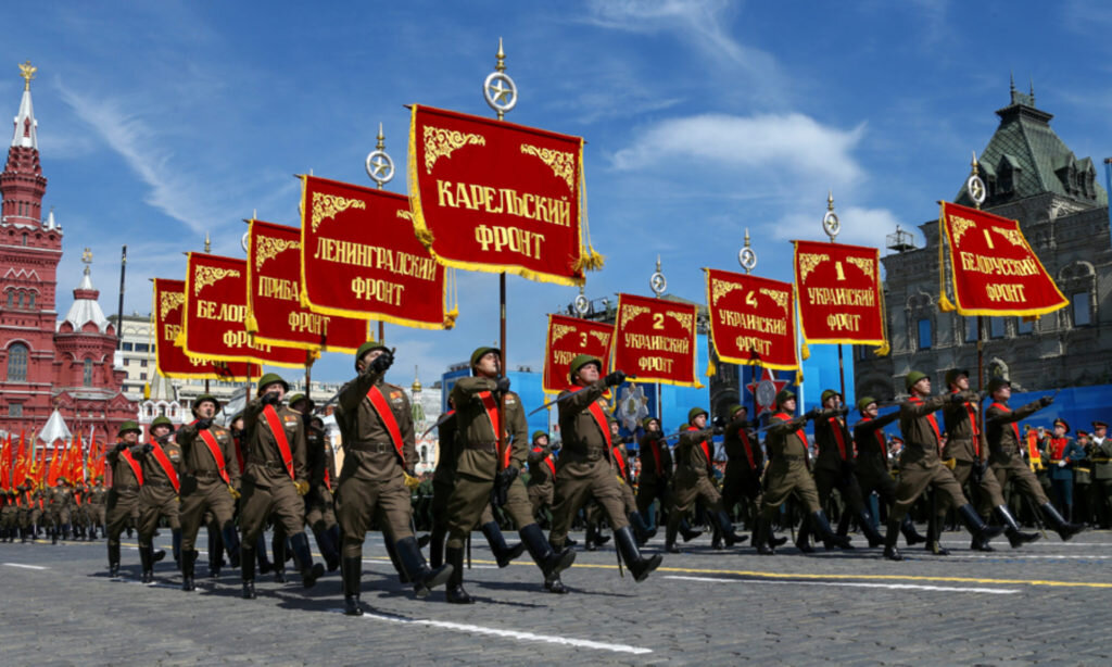Фото исторической части Парада Победы (бойцы в форме образца середины 1940-х годов проносят по площади штандарты фронтов Великой Отечественной войны)