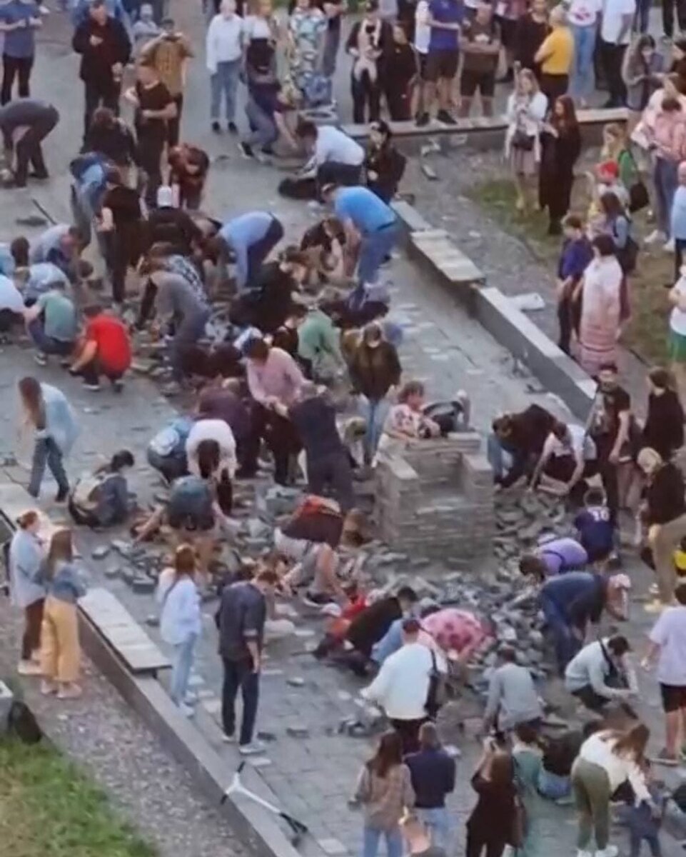 Жители Мурино кладут на место разобранную строителями (они пытались начать возведение фуд-холла) тротуарную плитку на место