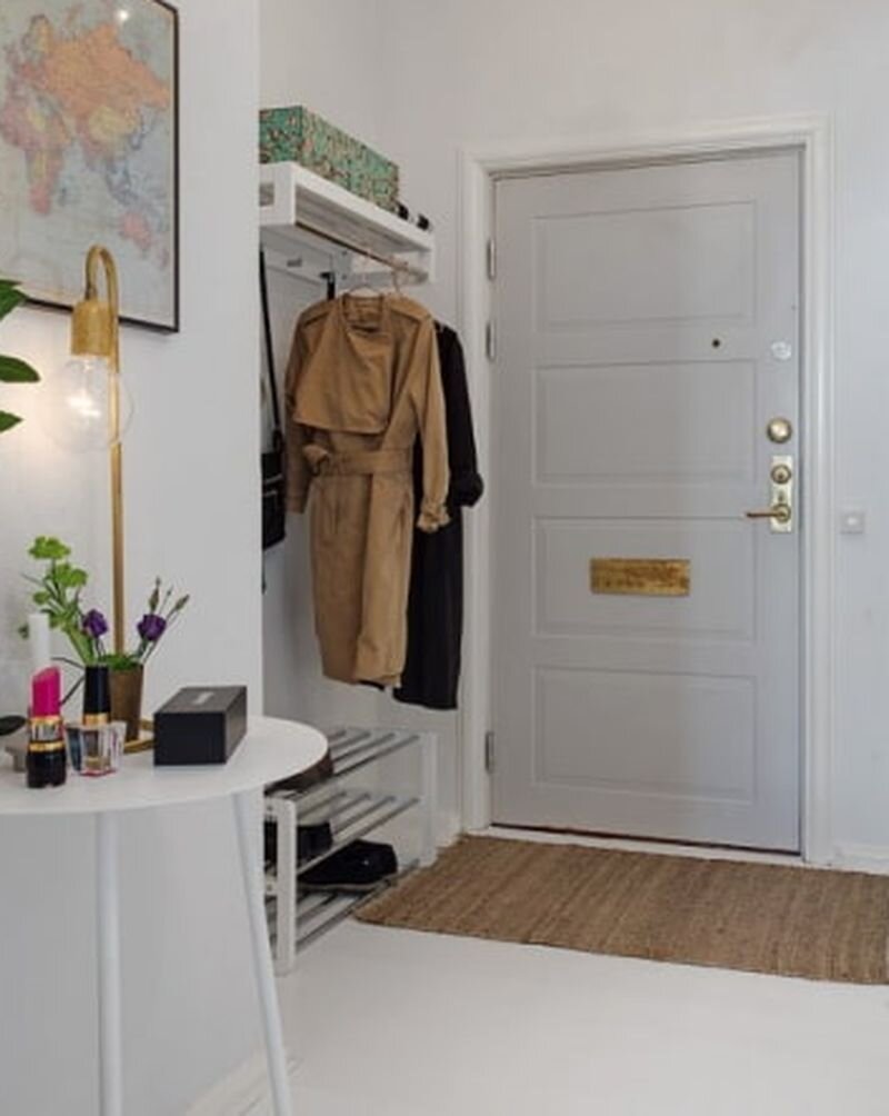 Металлическая входная дверь с филенчатой деревянной отделкой в интерьере прихожей.