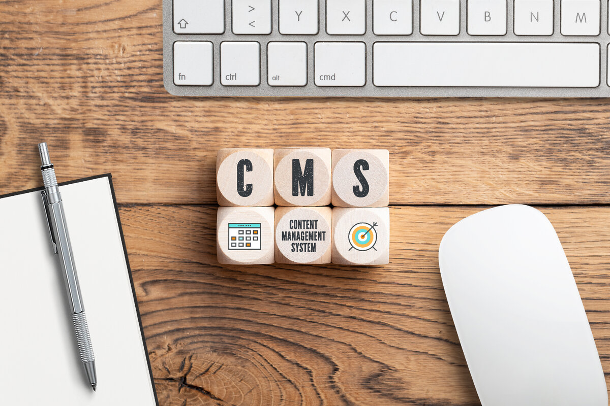 cubes with acronym CMS and a computer keyboard on wooden background. Автор: fotogestoeber