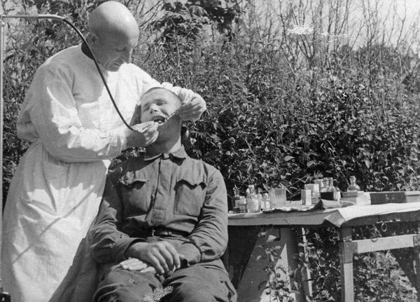 Зубной врач Е. Гальперин оказывает помощь ст. сержанту Поплескину. 1942 г | Фото: Иван Нарциссов