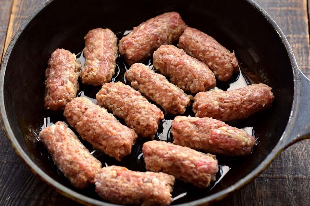 Жареные мясные колбаски на сковороде