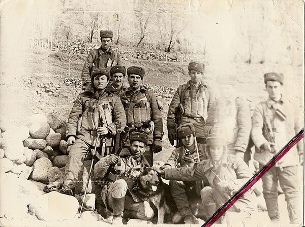 На многих форумах утверждается что на этом фото изображены сапёры 271-го отдельного инженерно-сапёрного батальона, которые погибли 1 мая 1984 года у кишлака Малима в ущелье Хазара в Панджшере, на следующий день после расстрела 1-го батальона 682-го мотострелкового полка. При этом стоящий слева с палкой - действительно похож на старшего лейтенанта Лабура Николая, командира инженерно-сапёрного взвода 271-го батальона - погибшего в тот день. Но все военнослужащие на этом фото - в зимней форме одежды. А переход на летнюю форму в этой части Афганистана осуществлялся в конце марта.  На снимке - в крайнем случае февраль. В мае-месяце там уже стояла жара под 35 градусов. Между днём когда сняли фото и началом мая - минимум два месяца. Так что это вряд ли именно те погибшие сапёры.  За пару месяцев в свете предстоящего майского "дембеля" - состав взвода мог кардинально поменяться.