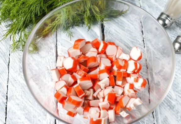 Как приготовить крабовый салат с морковью по-корейски: 
С крабовых палочек снимите упаковку и нарежьте их кубиками.