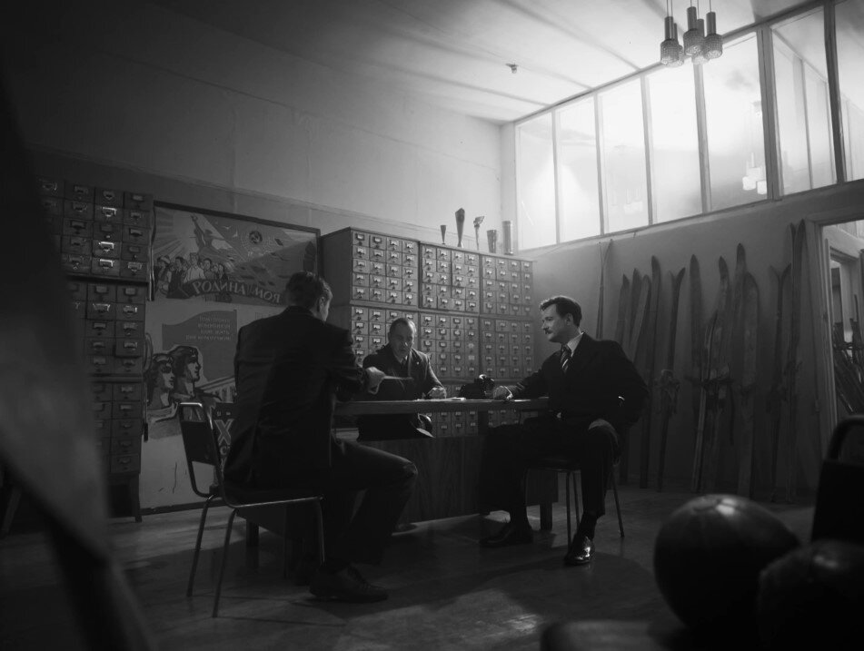 Игоря Дятлова знакомят с Семеном Золотаревым (кадр из сериала). Подход сотрудника КГБ к туристам выглядит не очень хорошо замаскированным. Неудивительно, что в ходе событий сериала Золотарева "раскрывают".