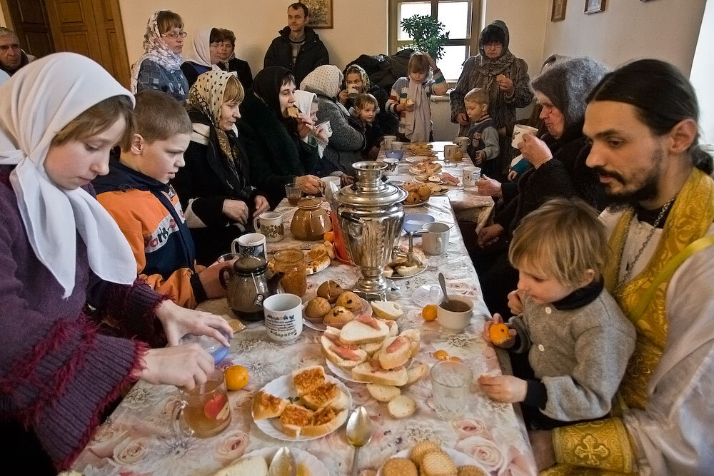 Подают в церкви. Православная община. Трапеза в храме. Православная семья за столом. Обед в монастыре.