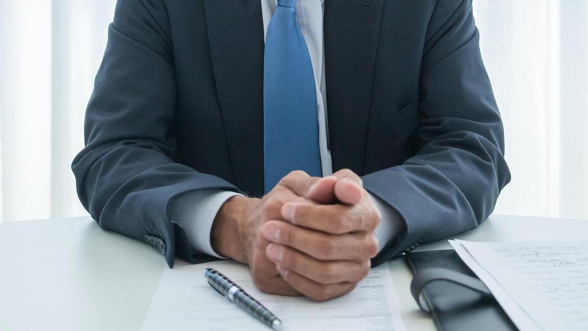    Мужчина в деловом костюме сидит за столом:pexels.com