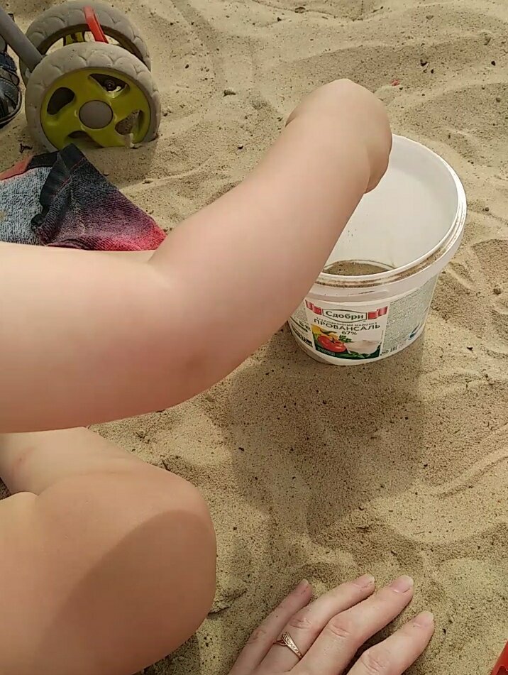 Насыпает песок руками