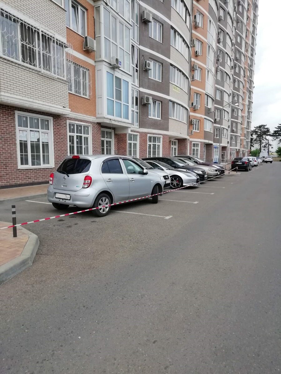 Берем полосатую ленту и начинаем освобождать площадку. Серебристый Ниссан перегородил два места, одна лента не удержит автомобили вечером. В результате на пять мест были размещены два автомобиля.