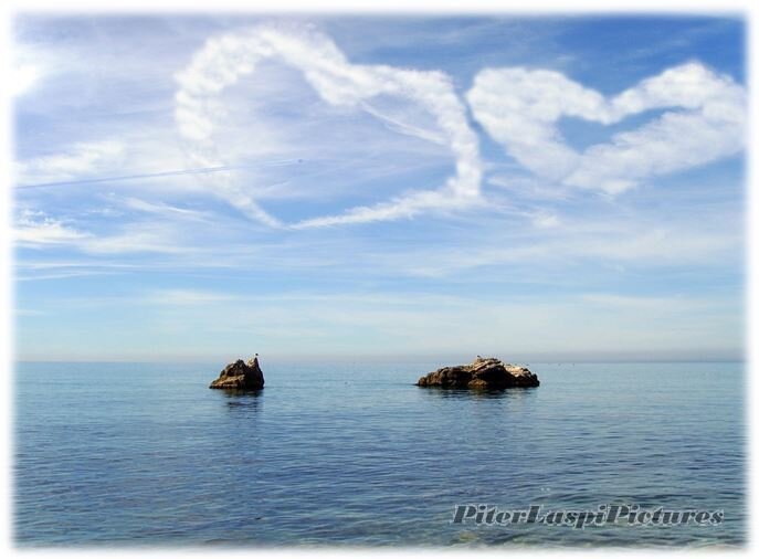 Сердца в небе над двумя чайками, сидящими на двух разных скалах в море. Бухта Ласпи.