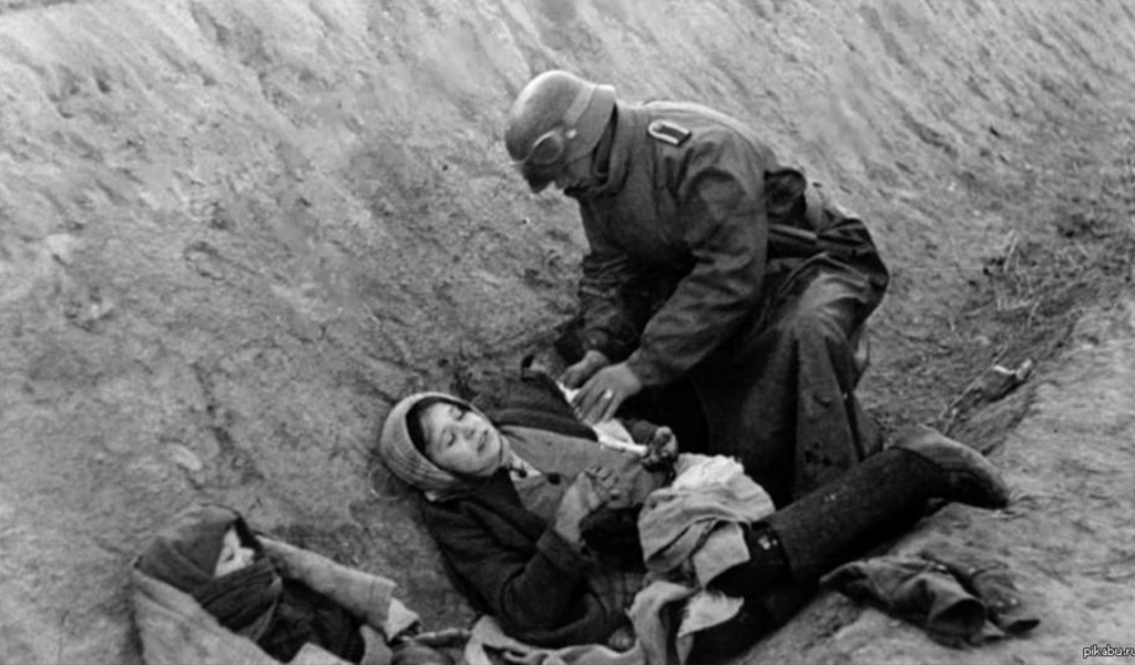 Немецкий солдат (мотоциклист-вестовой) перевязывает русскую девушку (1941 г.)