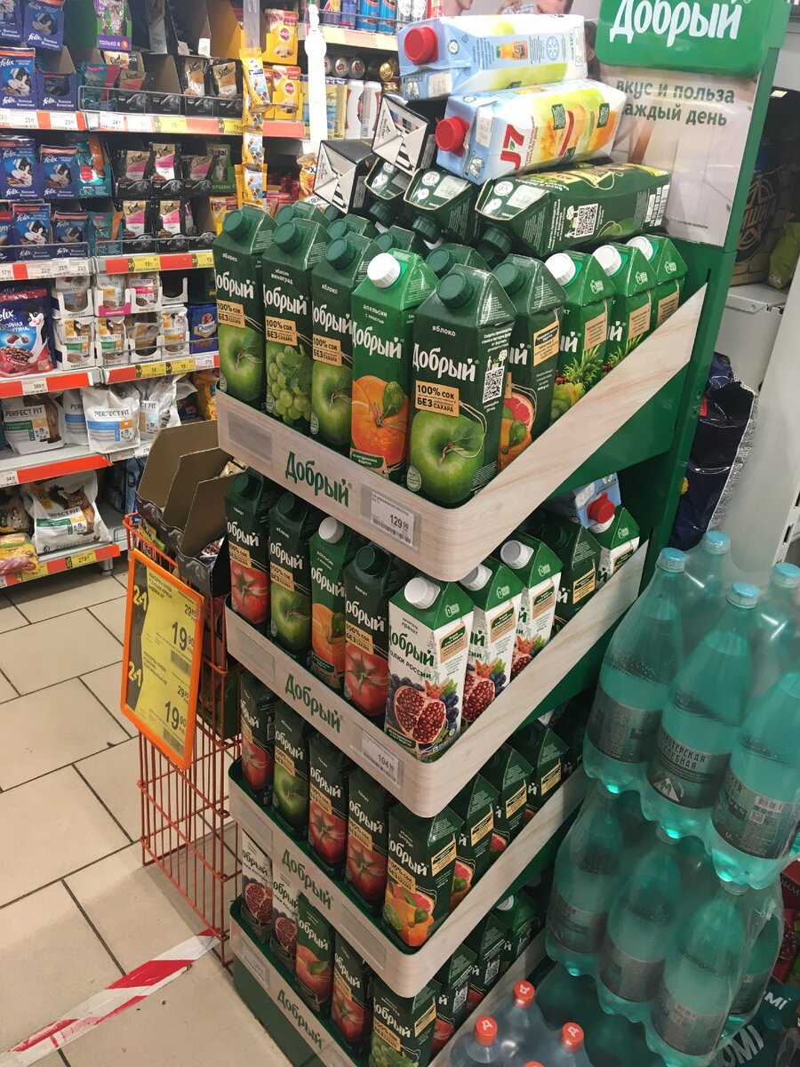 Фирменный стенд сока "Добрый" - мало того, что при таком разнообразии вкусов на стойке всего три ценника, так еще продукция расположена хаотично. И вишенка на торте: упаковки сока-конкурента J-7, наваленные сверху.