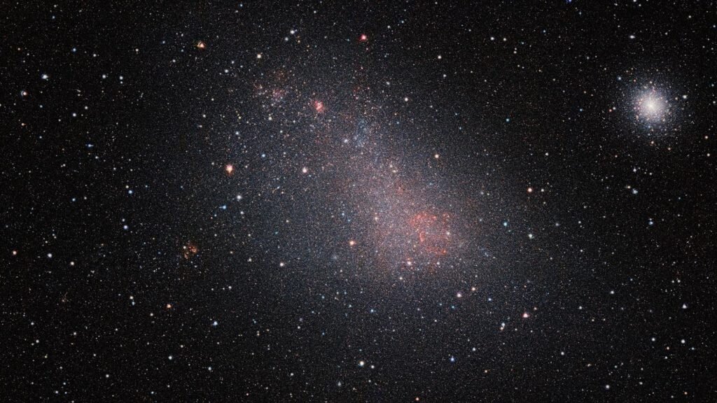    The Small Magellanic Cloud (SMC) galaxy is a striking feature of the southern sky even to the unaided eye. But visible-light telescopes cannot get a really clear view of what is in the galaxy because of obscuring clouds of interstellar dust. VISTA’s infrared capabilities have now allowed astronomers to see the myriad of stars in this neighbouring galaxy much more clearly than ever before. The result is this record-breaking image — the biggest infrared image ever taken of the Small Magellanic Cloud — with the whole frame filled with millions of stars. As well as the SMC itself this very wide-field image reveals many background galaxies and several star clusters, including the very bright 47 Tucanae globular cluster at the right of the picture. Александр Шереметьев