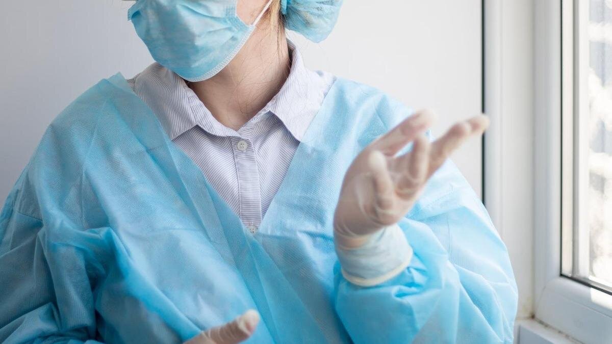    Медсестра в маске стоит у окна:pexels.com
