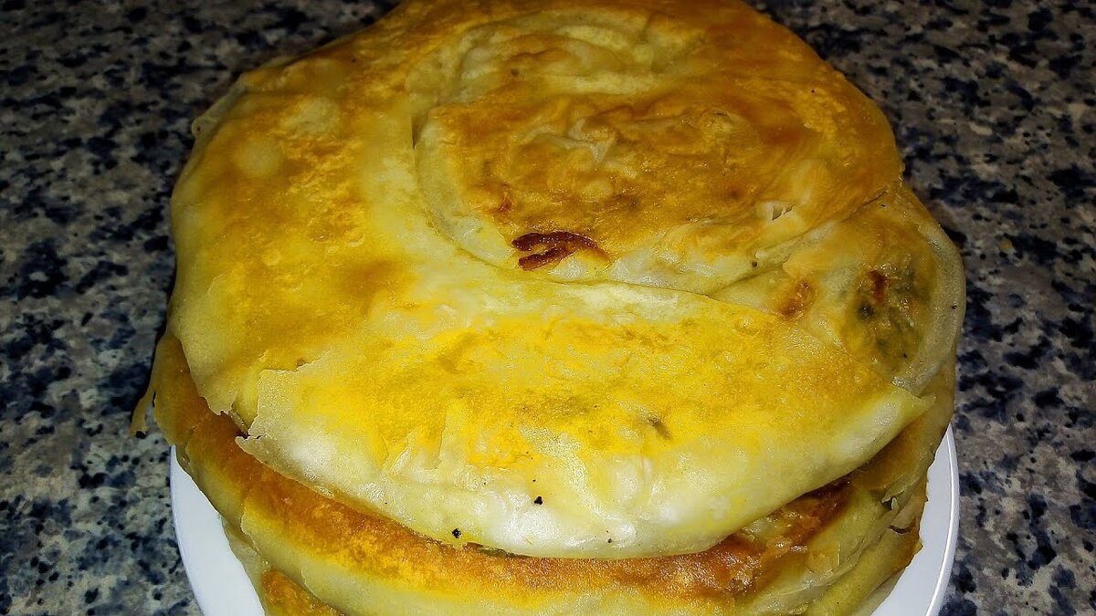 Узбекская катлама - это жареная слоеная лепешка из пресного теста, с начинкой или без нее. Существуют несколько способов приготовления катламы. Предлагаю самый простой. 
Ингредиенты на 5 шт.:
Тесто:
мука пшеничная - 625 гр.
соль - 1 ч.л.
вода - 375 мл.
Начинка:
лук репчатый - 5 шт.
зелень петрушки - 1 пучок
соль и черный перец по вкусу
сливочное масло растопленное - 50 мл.
масло растительное для жарки

Замесить тесто, разделить на 5 частей и убрать на 30 минут. Лук мелко нарезать, добавить зелень, посолить и поперчить по вкусу. Все немного примять, жидкость слить. Раскатать тесто в тонкий пласт, смазать сливочным маслом. Сверху выложить немного начинки. Свернуть плотно в рулет, затем в улитку. Руками придать форму лепешки толщиной 1 см. Обжарить в небольшом количестве масла с двух сторон на маленьком огне под закрытой крышкой. 