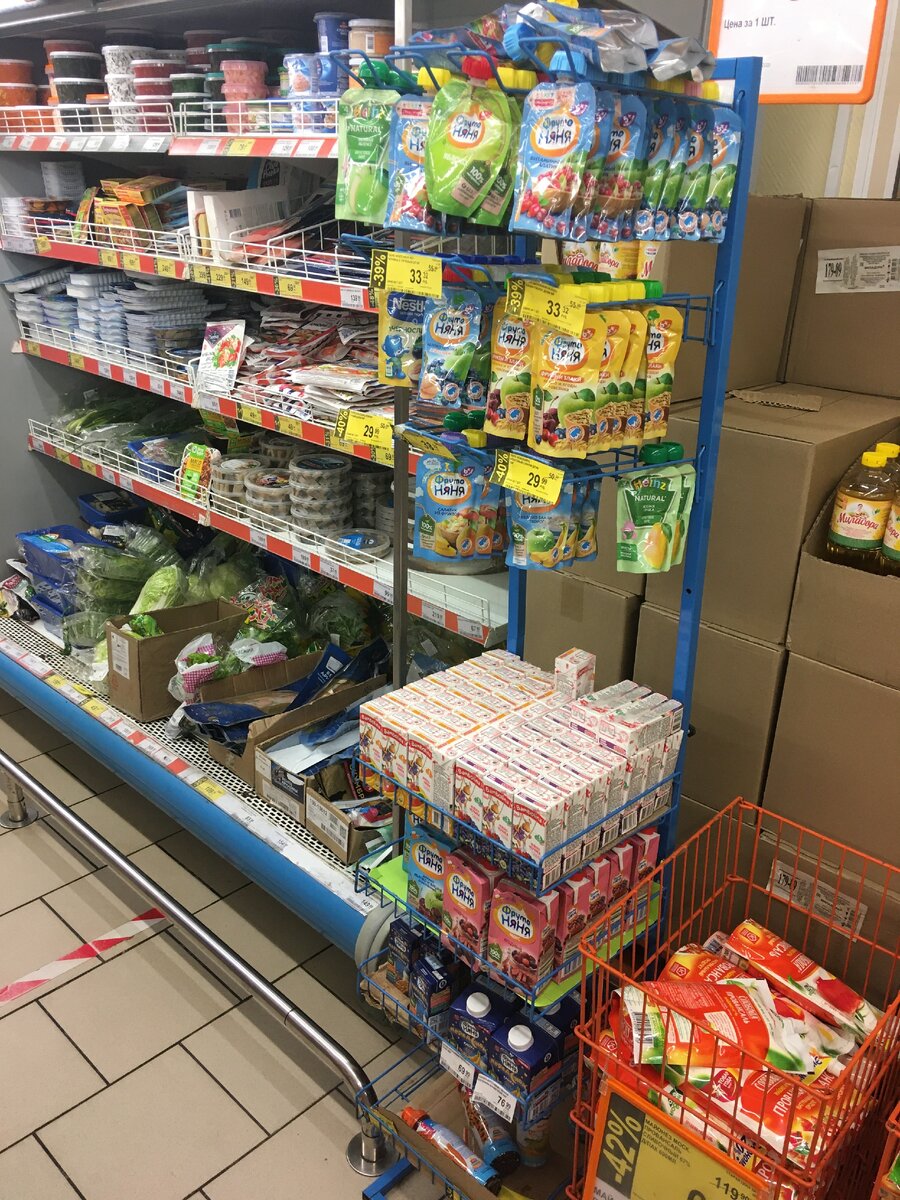 Стойка с детским питанием - также беспорядок, упаковки просто набросаны сверху. Коробки на заднем фоне не добавляют красоты.