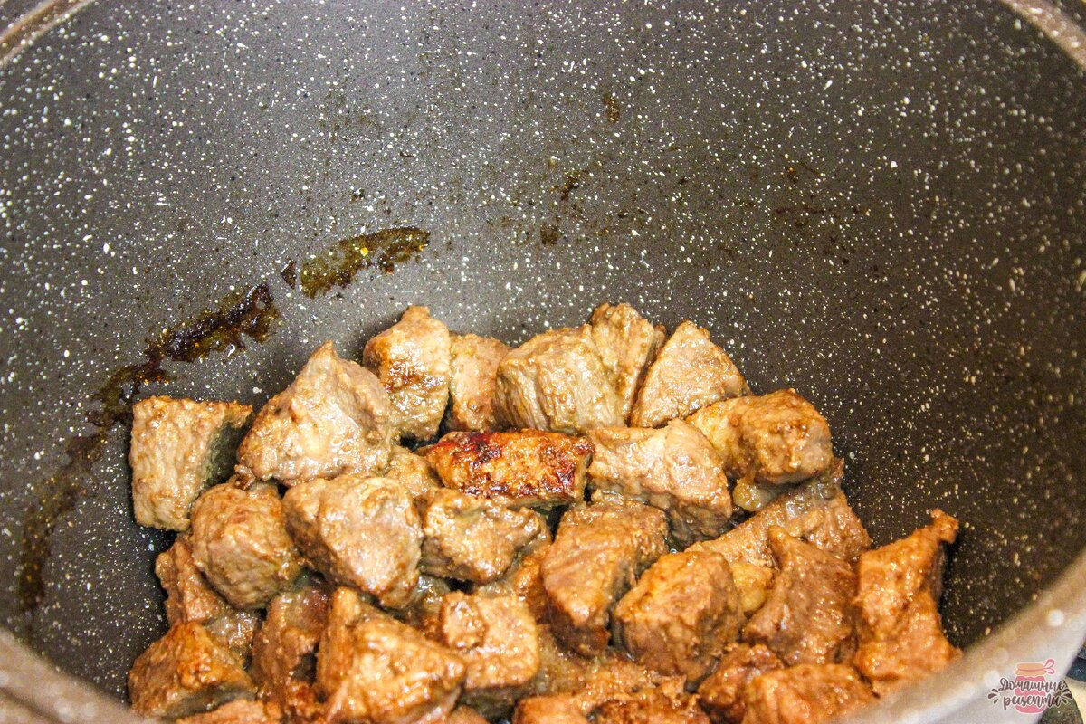 Мясо помыть, нарезать на средние кусочки.  В кастрюле с толстым дном разогреть масло, положить мясо и жарить без крышки, пока вся вода не выпарится а мясо начнёт румяниться. 