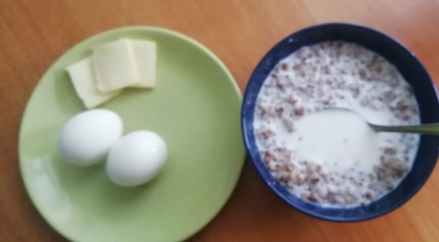 Гречневая каша с молоком, два вареных яйца и сыр.