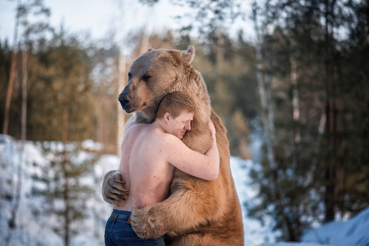 Медведь обнимает мужика