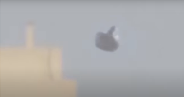 Крайне близко от НЛО расположены здания, деревья и заводы