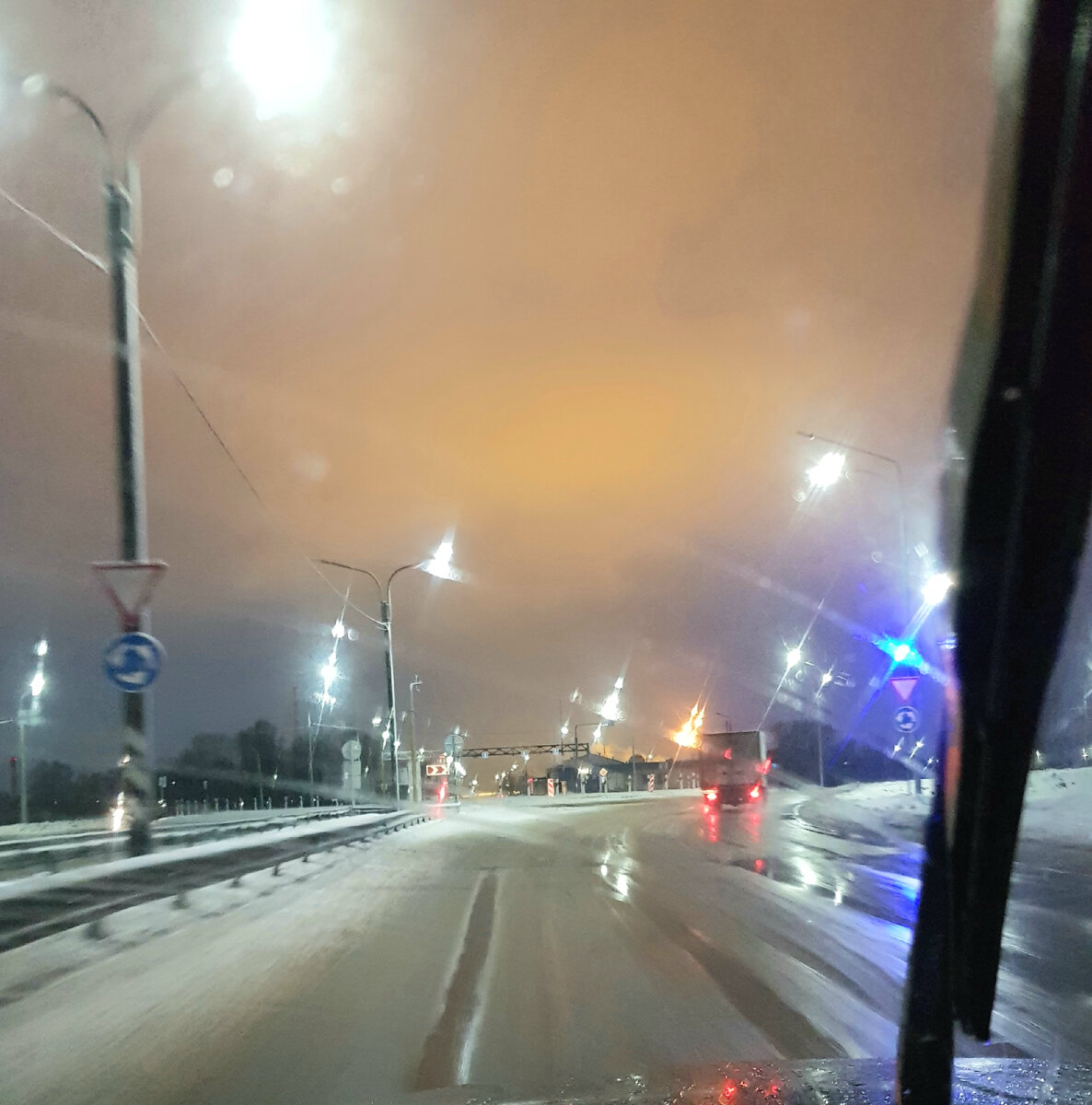 8 утра на въезде в Череповец, +1 C. 
Слева дорожные указатели о круговом движении, справа - маячок, спереди - "кольцо", сверху - жёлтое свечение тепличного комплекса