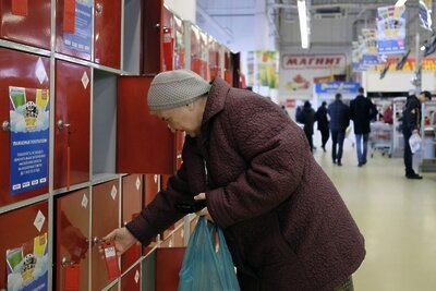    Пожилая женщина кладет вещи в камеру хранения в магазине ©Николай Хижняк РИА Новости