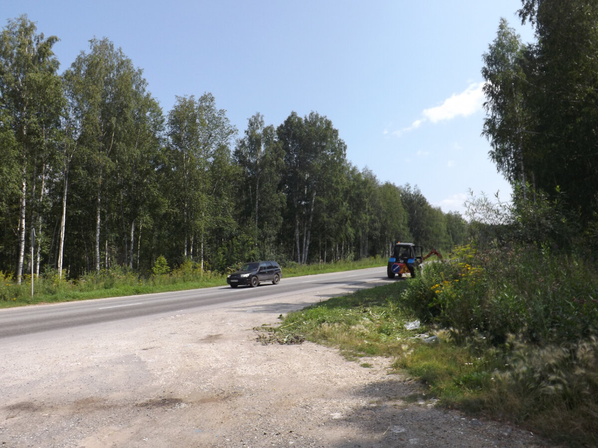 Трактор подчищает обочину дороги