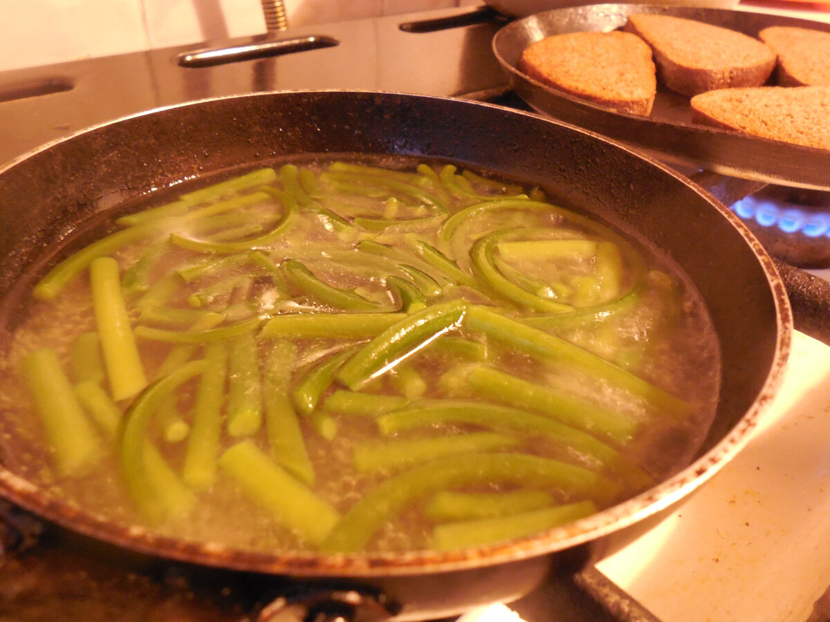 К чесночным стрелкам (на первой сковородке) греется хлеб. Хлеб из морозильника. Быстро нагреется, будет мягким и с аппетитной корочкой