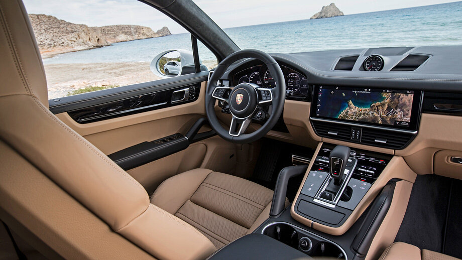 Пластика интерьера стала более обыденной, но в качестве материалов ― никаких компромиссов. Все три зеркала некрупные, зато зона очистки лобового стекла огромна. Включение заднего дворника ― неудобной мелкой кнопочкой в торце рычажка. 
Странно, что в Porsche пошли на поводу у сенсорной моды. Включить на ощупь, например, вентиляцию сиденья невозможно, отвлекаешься от дороги на секунду-другую. На максимальных 286 км/ч, которые развивает Cayenne Turbo, это 100–150 м езды вслепую! С медиасистемой на поршевских скоростях развлекаться и не хочется. Но на медленной тряской дороге попадать в её виртуальные кнопки тоже сложно. А больше всего жалко утраченную физическую кнопку «назад» ― пусть даже её сенсорный клон остался на тоннеле. Зато базовая эргономика ожидаемо великолепна, кресла шикарны, и даже нефиксируемый селектор автомата не вызывает отторжения.