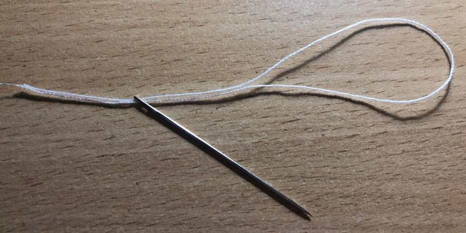 складываем отрезок напополам, совмещённые концы продеваем в ушко, подтягиваем так, чтобы с другой стороны образовалась петля