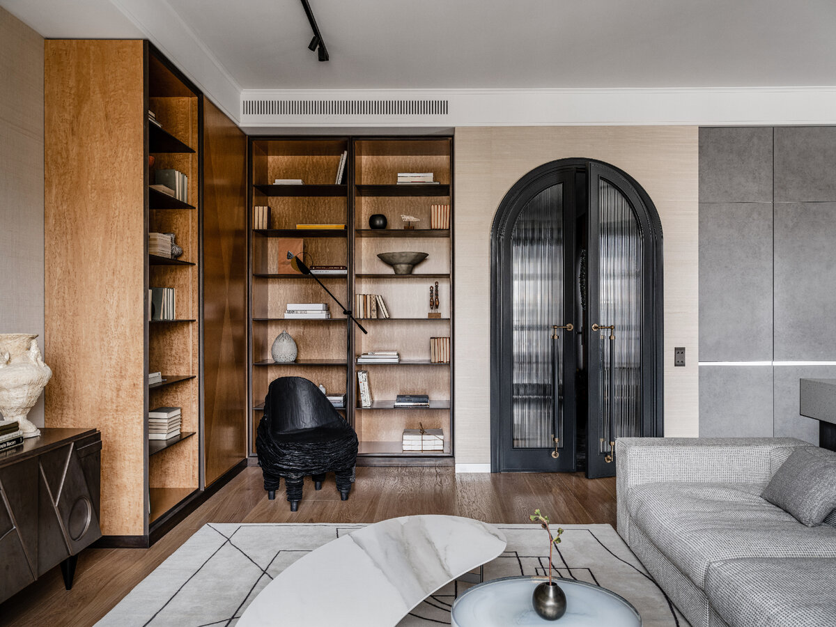 Общий вид гостиной. Библиотека сделана по эскизам Анны Зиньковской. Вазы на полках из Moon-stores, кресло Black Paper по дизайну Вадима Кибардина из Alina Pinsky Gallery, торшер Bolia, диван Flexform, ковер из Dovlet House. Обои Yana Svetlova. 