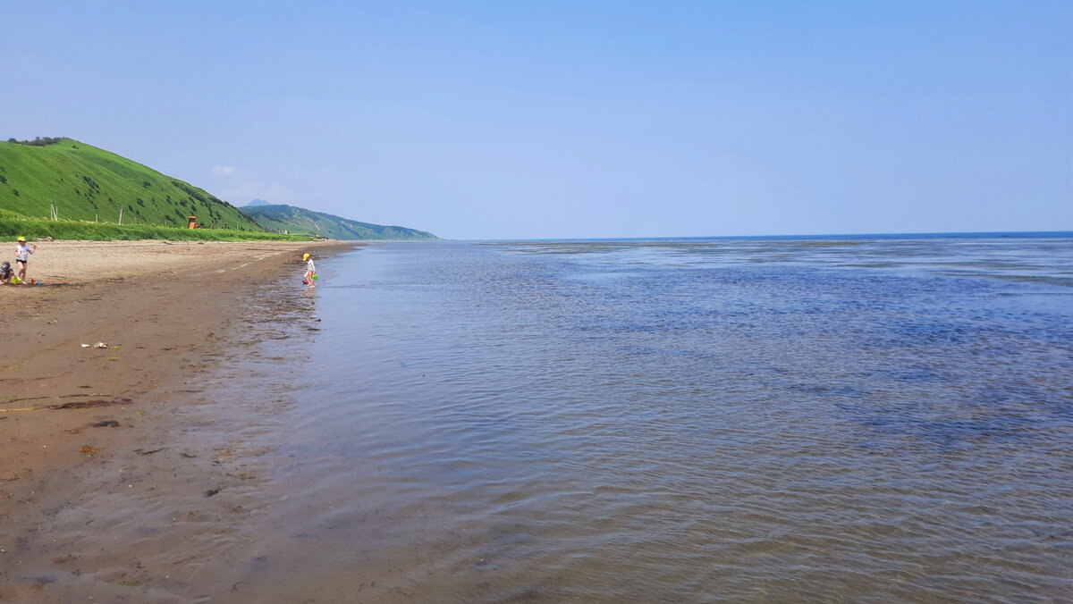 Дикий пляж, отлив.  На море всего пару человек.