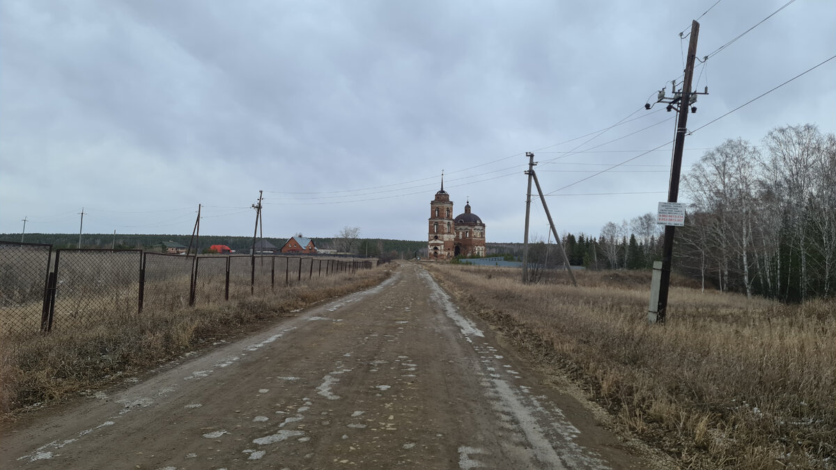 Вдали виднеется высокая из красного кирпича церковь.