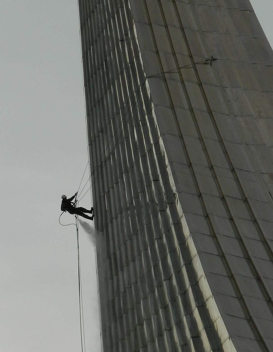 Рабочий моет памятник. Почти космонавт взбирается в корабль.