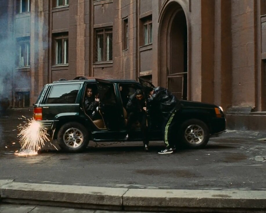 Крашеный Grand Cherokee не обязательно следствие ДТП. Многие машины получали "огнестрельные" повреждения на разборках. Кадр из К/Ф "Брат-2"