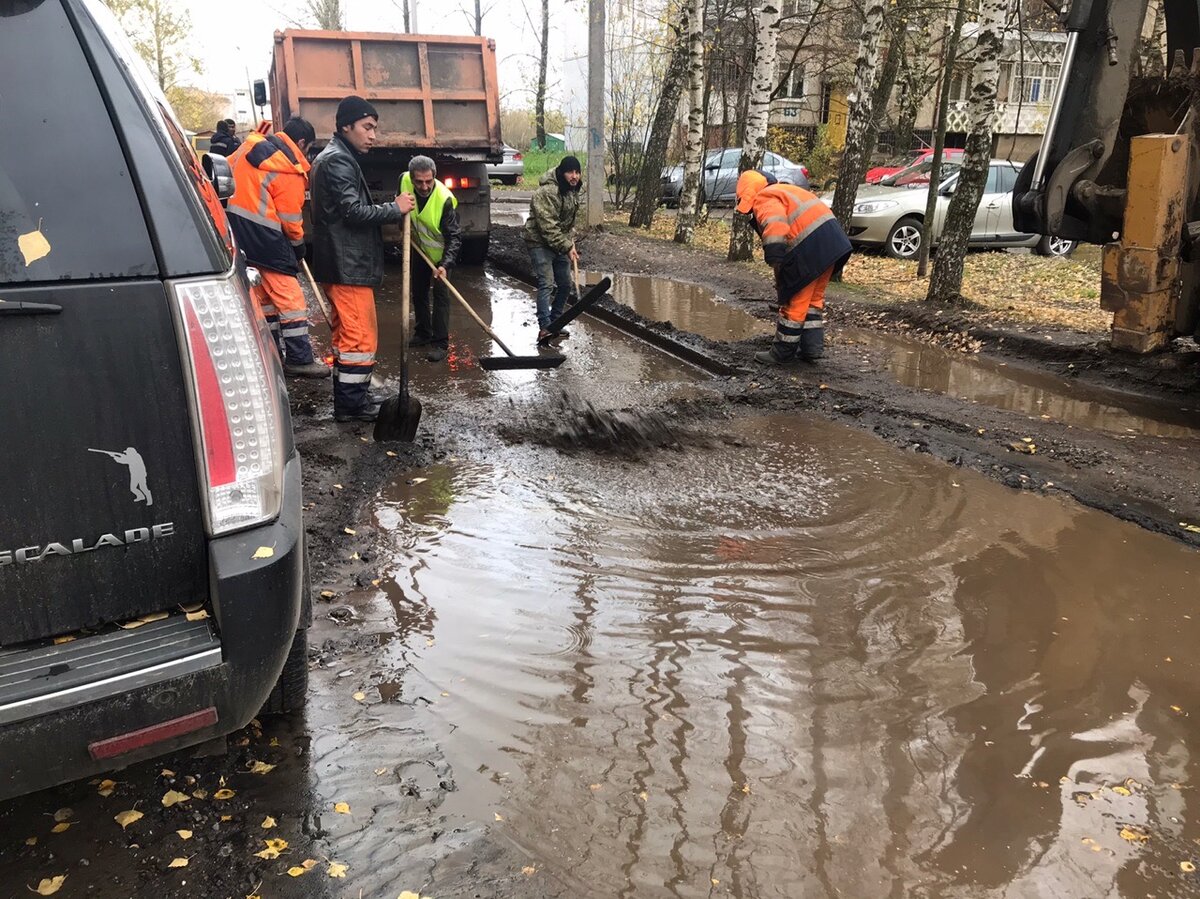 Дождь асфальт. Лужа на асфальте. Укладка асфальта в лужи. Укладка асфальта в лужи в России. Дорожники кладут асфальт.