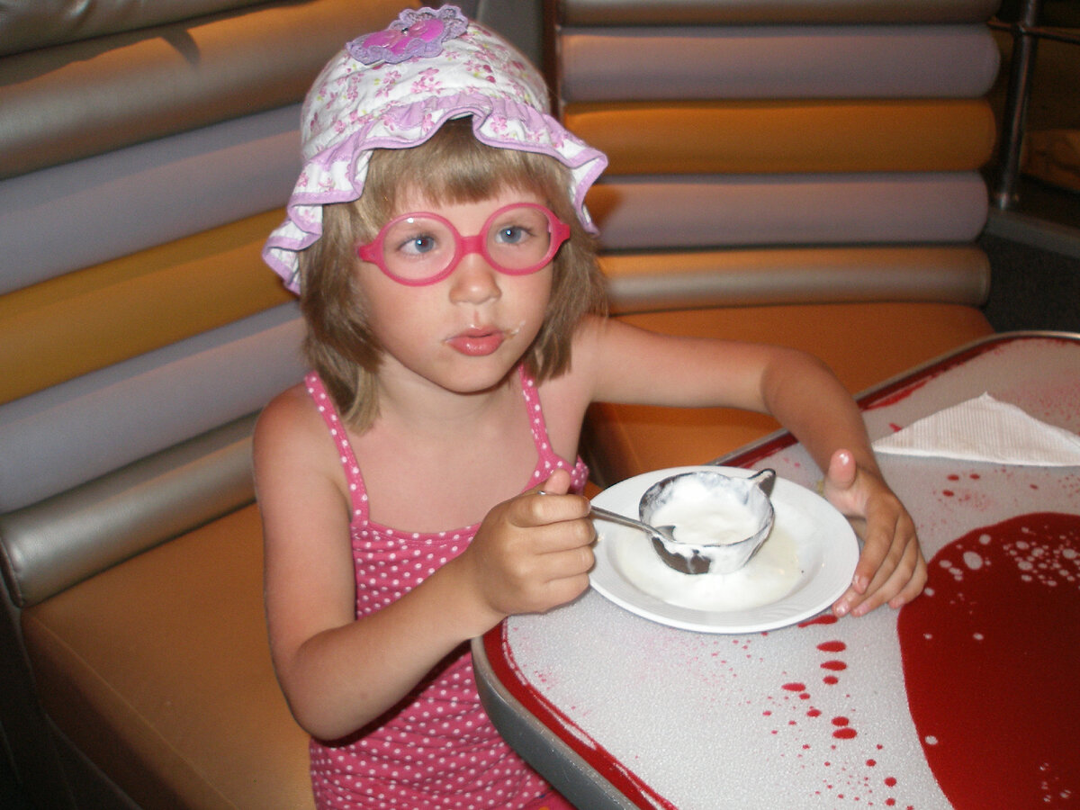 Дочь ест мороженое шоколадной ложкой из шоколадной чашки в Крыму. 2013 г.