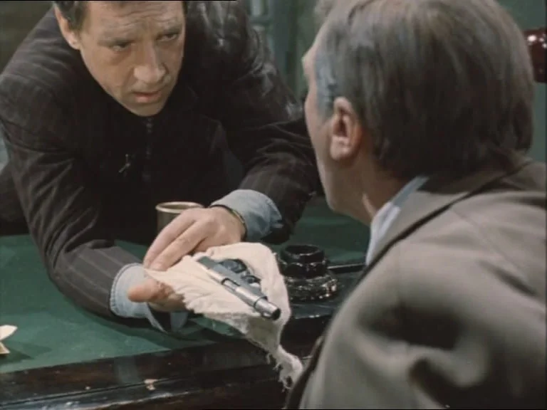 Глеб Жеглов показывает пистолет Груздеву в качестве доказательства своей серьёзности