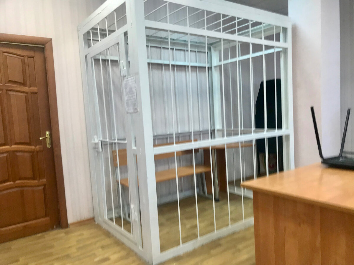 В зале суда даже клетка имеется!