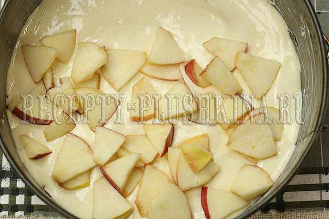 Итак, приступаем. Достаем все продукты по списку, вынимаем из коробки миксер и включаем духовку. Пока делаем тесто для шарлотки и режем яблоки, духовой шкаф наберет температуру 180 градусов. Берем глубокую миску, в которой удобно взбивать, разбиваем три яйца. Всыпаем половину сахара. 
 Начинаем взбивать на невысокой скорости, работаем миксером, пока не добавим весь сахар. Яично-сахарная масса начнет густеть и пениться. Постепенно увеличиваем обороты почти до максимума. Перемещаем венчики по всему объему, захватывая возле стенок, наклоняя миску. Должна получиться пышная масса, кремообразная, гладкая. Чем лучше вы взбиваете яйца с сахаром, тем пышнее получится основа для пышной шарлотки с яблоками. Можно считать смесь хорошо взбитой, когда она перестает увеличиваться в объеме и не меняет консистенцию при дальнейшем взбивании. Проще говоря – и не густеет и не опадает.   Смешиваем муку, разрыхлитель и ванилин. Просеиваем сквозь мелкое сито. Добавляем мучную смесь к взбитой массе. Замешиваем осторожно, как бы поддевая снизу и заворачивая наверх. Несмотря не добавленный разрыхлитель, тесто нельзя взбивать, пена может опасть и пышная шарлотка в духовке не получится.  Совет. Не забывайте просеивать муку. Просеивая, вы наполняете ее кислородом и очищаете от примесей. Из плотной, лежалой муки хорошей выпечки не ждите. Вымешиваем ложкой несколько минут, пока смесь не станет однородной и воздушной. Консистенцию хорошо видно на фото – тесто как бы тянется, медленно стекает широкой волной.  Форму промазываем сливочным маслом и выкладываем треть или чуть более теста. Слой делаем ровным. Яблоки разрезаем на четыре части, вычищаем сердцевину с семенами, режем небольшими кусочками. Кожуру не срезаем – она совершенно не мешает. Пока шарлотка с яблоками печется в духовке, кожица на яблочных дольках успеет размягчиться и даст приятную кислинку готовой выпечке. Кроме того, дольки останутся целыми, и выглядеть шарлотка с яблоками будет эстетичнее. 
