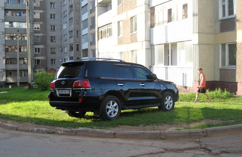 Типичный автомобиль класса жир под окнами среднестатистического жилого дома