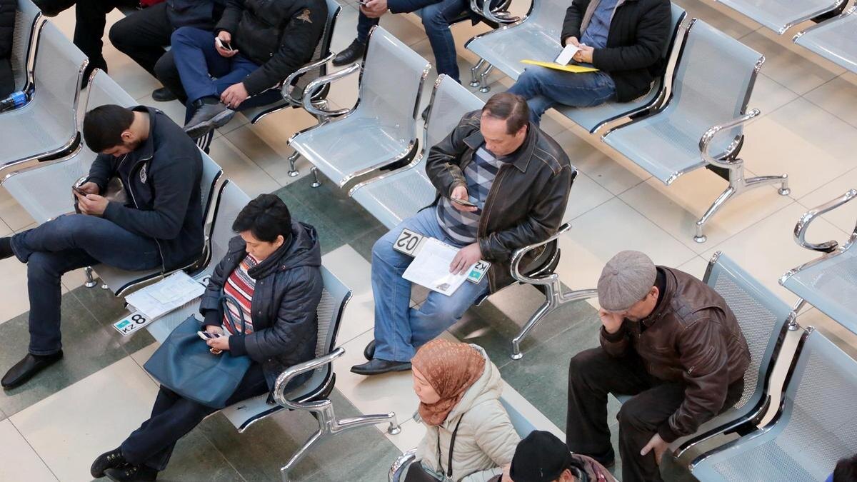    Люди сидят в очереди:NUR.KZ / Петр Карандашов