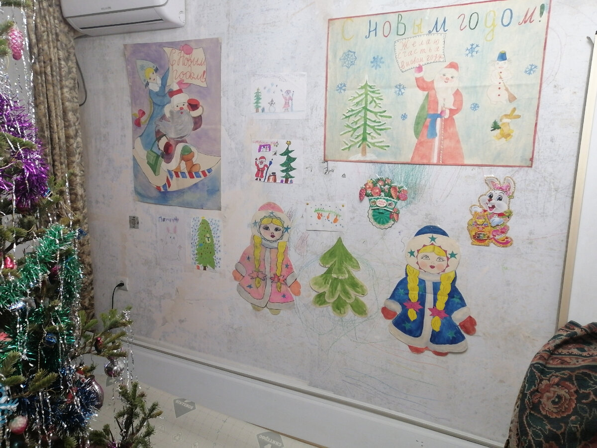 Новогодние украшения в родительском доме. Снегурочка в синем когда-то была мешком, в котором я получила новогодний подарок от учительницы в первом классе - нарисована лично учительницей. Снегурочку в розовом и ёлочку между ними нарисовала моя бабушка в том же 1989 году - они до сих пор живы и каждый новый год украшают комнату. Левый плакат когда-то нарисован сестрой, правый - примерно тогда же мной, все маленькие рисунки нарисовала моя дочь уже в этом году