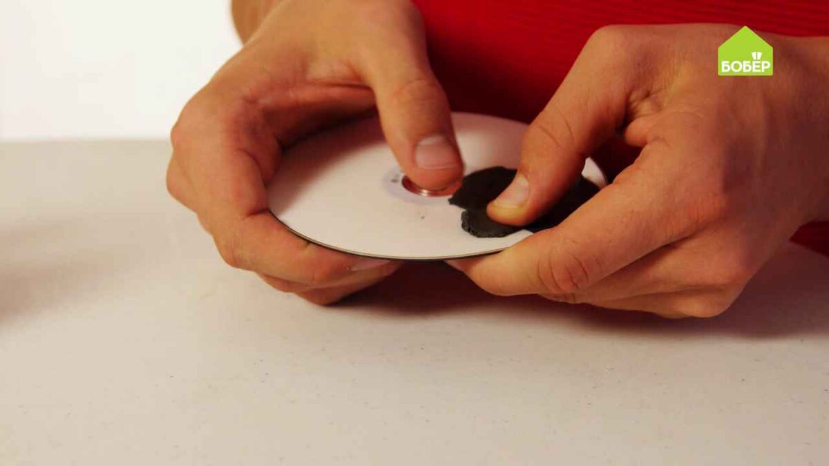 Подставка для чашки из компакт-диска
На одну сторону диска налепите пластилин тёмного цвета.